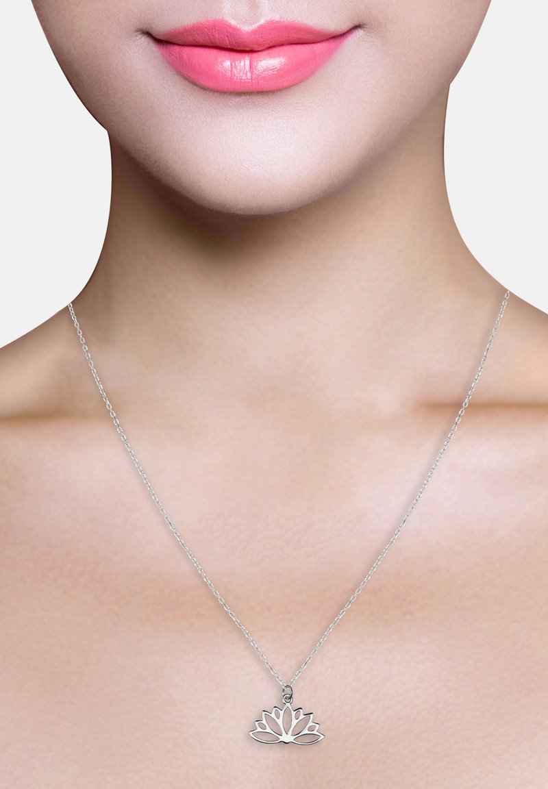 Collier en argent avec un pendentif en fleur de lotus, présentant un design découpé complexe. La chaîne est fine et délicate, complétant le pendentif.