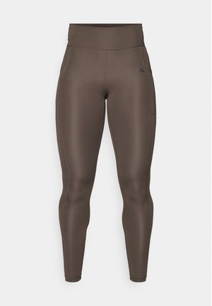 Brown athletic leggings with a high waist, smooth texture, side pocket, and subtle logo detail. Form-fitting design for comfort and movement.