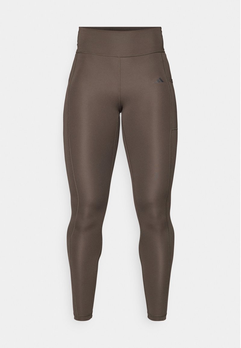 Leggings de sport marron avec taille haute, texture lisse, poche latérale et détail de logo subtil. Design ajusté pour le confort et le mouvement.