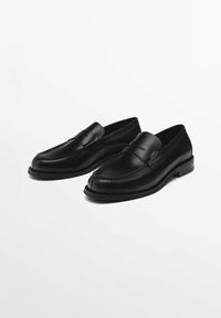 Schwarze Lederloafers mit glatter Oberfläche, ausgestattet mit einer genähten Akzentuierung an der Spitze und einem niedrigen, gestapelten Absatz. Minimalistisches Design ohne Verzierungen.