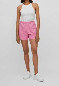Rosa bomullsshorts med resårmidja, kombinerat med en vit ribbad linne och vita sneakers. Enkelt mönster med en mjuk textur.