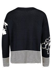 Pull en tricot noir avec des motifs floraux blancs sur les manches et un ourlet rayé. Il possède un col rond et une coupe ample.