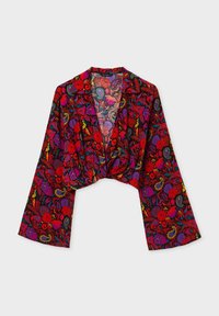 Giacca cropped realizzata in tessuto leggero, caratterizzata da un intricato motivo floreale e paisley in rosso, viola e verde su uno sfondo nero.