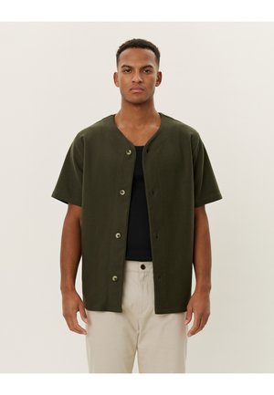 Donkergroene korte mouw blouse met v-hals, gemaakt van zachte stof, met een relaxte pasvorm en zilveren knopen als accent.
