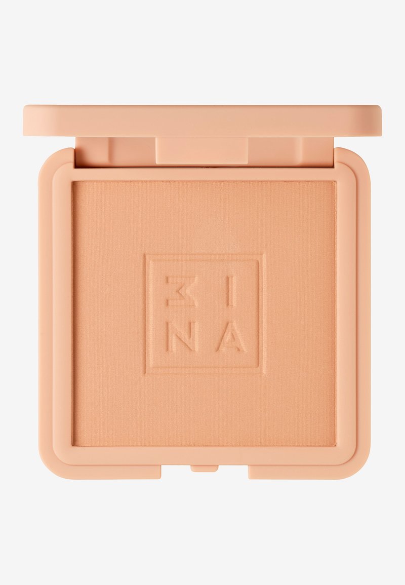 Pressat puderkompakt i ljus persika. Slät textur, har präglad logotyp, fyrkantig form och ett säkert flip-top lock.