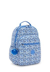 Mochila azul con un patrón geométrico, que incluye un bolsillo frontal con cremallera y un charm azul peludo en el tirador de la cremallera. Tela texturizada.