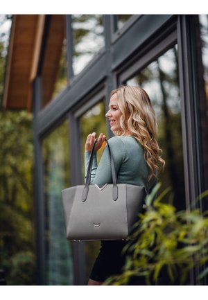Grau Handtasche mit strukturiertem Design, glatter Textur und doppelten Griffen. Verfügt über ein dezentes, V-förmiges Akzent und Logo auf der Vorderseite.