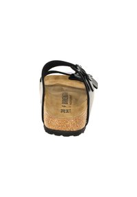 Sandale noire avec une semelle en liège, sangle ajustable et accent de fleur décoratif. Surface lisse et semelle intérieure texturée pour le confort. Taille 38.