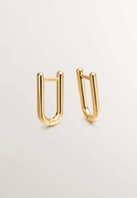 Pendientes de aro de metal dorado con un diseño en forma de U, superficie lisa y acabado pulido. Cuenta con un cierre de bisagra simple.