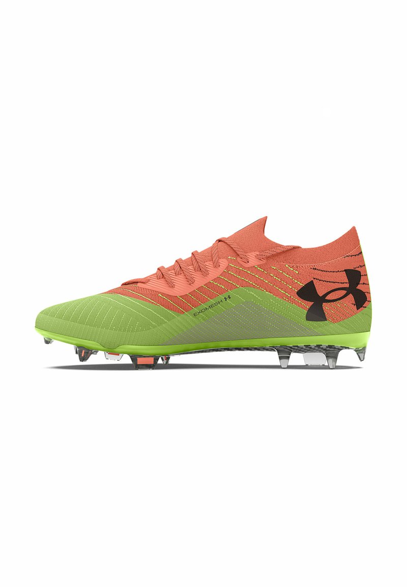 Botas de fútbol naranja y verde con parte superior texturizada, diseño de cordones y tacos moldeados. Presenta una marca en el costado y patrones intrincados.