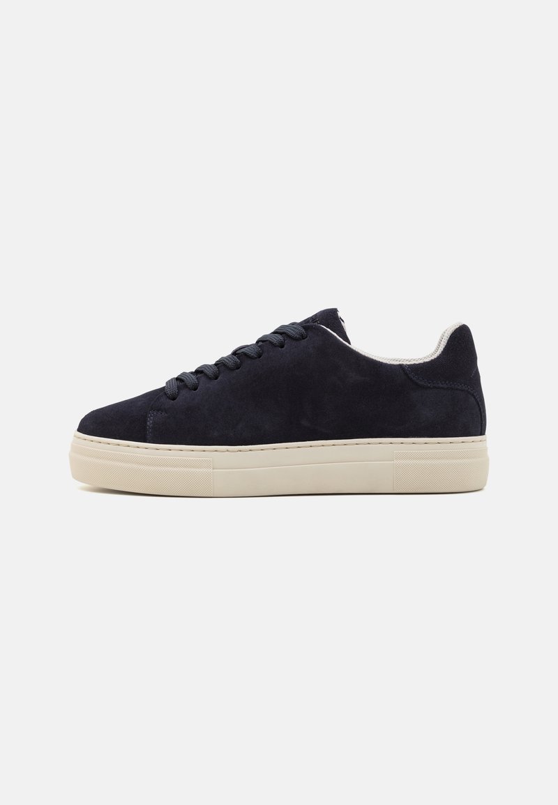 Tenisi negri din suede cu profil jos, vârf rotund și talpă din cauciuc bej în contrast. Dispune de șireturi tonale și căptușeală din textil moale.