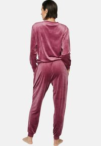Fluwelen pyjama set in mauve, met een losvallend top met lange mouwen en bijpassende joggerbroeken met elastische manchetten en zijkanten zakken.