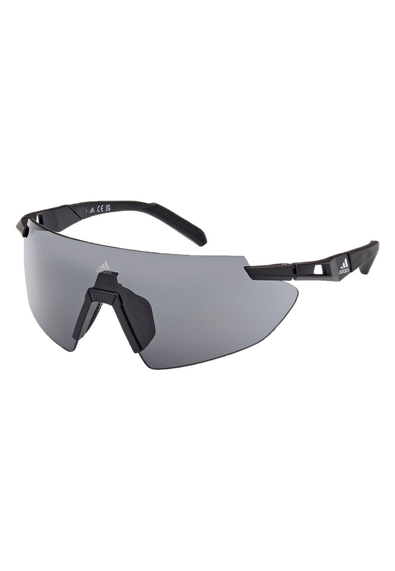 Ochelari de soare sport cu un cadru din plastic negru, aerodinamic, lentile mari de culoare gri închis și accente distincte pe sprânceană. Vârfuri texturate ale brațelor pentru o prindere mai bună.