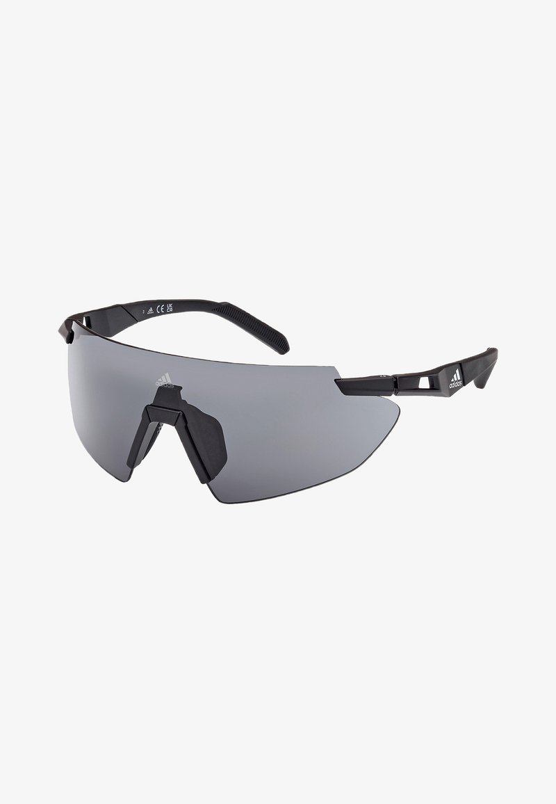 Ochelari de soare sport cu un cadru din plastic negru, aerodinamic, lentile mari de culoare gri închis și accente distincte pe sprânceană. Vârfuri texturate ale brațelor pentru o prindere mai bună.
