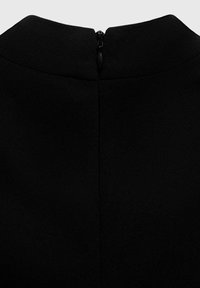 Black garment featuring a close-up view of the back with a visible zipper. The fabric appears smooth, with a structured neckline.