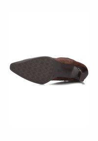 Brown suede heeled shoe viewed from the bottom, showing patterned sole, size 38, and stacked block heel.