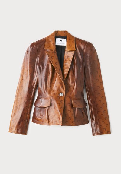 Barna bőr blézer fényes felülettel, félhold mintákkal, kivágott gallérral, két elülső zsebbel és egy gombos záródással.