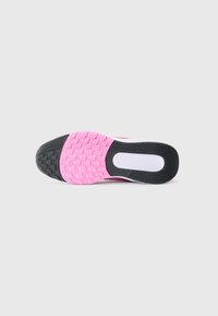 Semelle d'une chaussure de course avec un motif de semelle noir, rose et blanc sur un fond blanc uni.