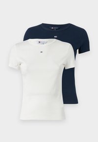 Due magliette a maniche corte, una bianca e l'altra blu navy, realizzate in tessuto a coste. Ognuna presenta un piccolo logo sul petto e un collo rotondo.