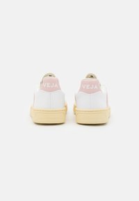 Sneaker bianchi in pelle con linguette sul tallone di un delicato rosa e branding "VEJA", caratterizzati da una suola in gomma testurizzata di un morbido colore giallo.
