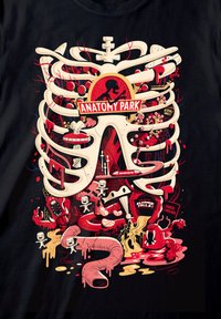 Černé tričko s karikaturním grafickým vyobrazením hrudníku, lebek a červených prvků, označené „ANATOMY PARK“, s různými hravými detaily.