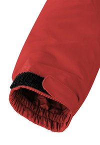 Rote isolierte Handschuhe mit strukturiertem Äußeren, elastischem Bündchen, schwarzem Klettverschluss und sichtbarer innerer Fütterung an der Öffnung.
