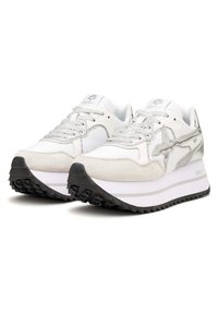 Scarpe da ginnastica bianche con accenti argento, una punta in suede testurizzato e una suola spessa bianca con battistrada nero. Lacci scintillanti completano il design.