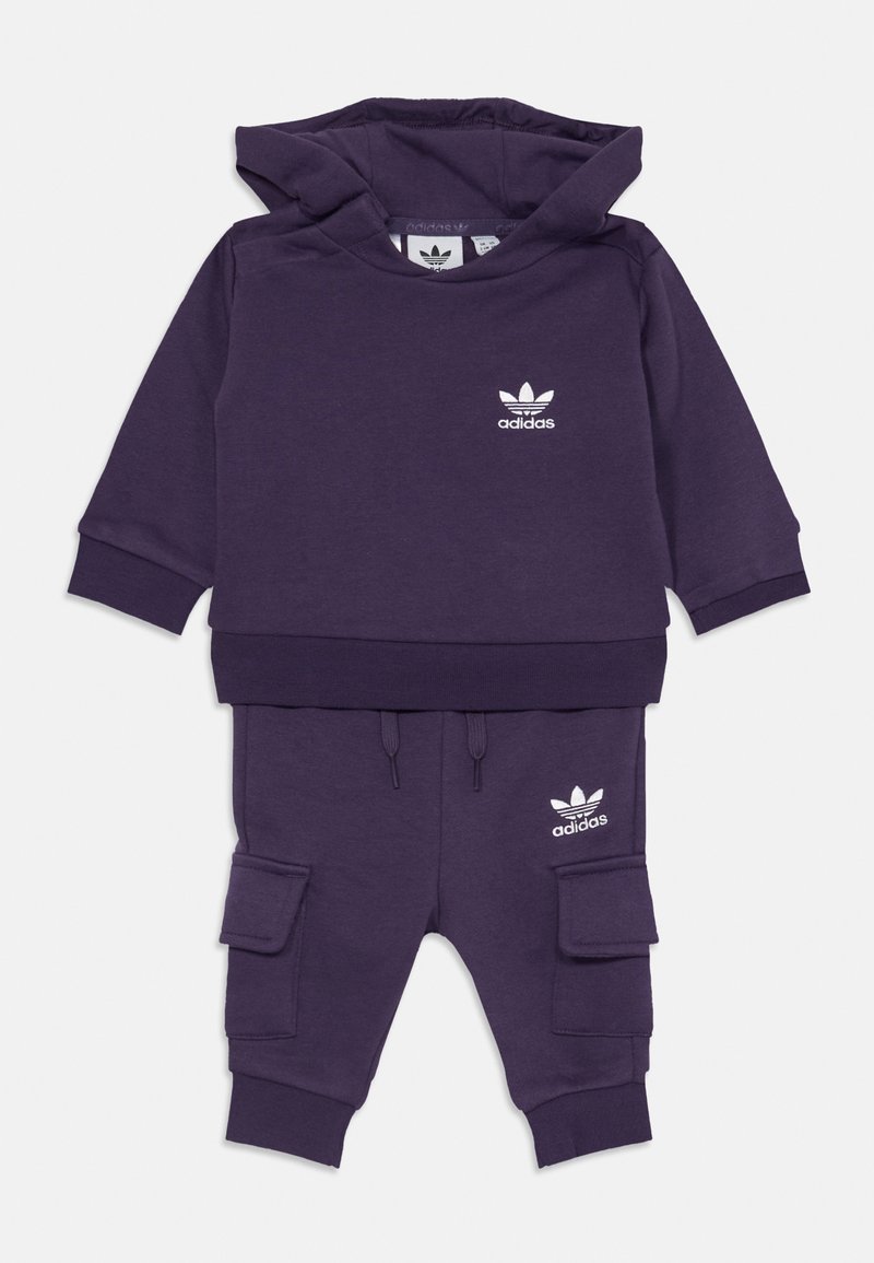 Purple set za dojenčke, ki vključuje kapuco in cargo hlače z belimi logotipi Adidas na prsih in stegnu, z rebrastimi manšetami ter nastavljivim pasom z vrvico.