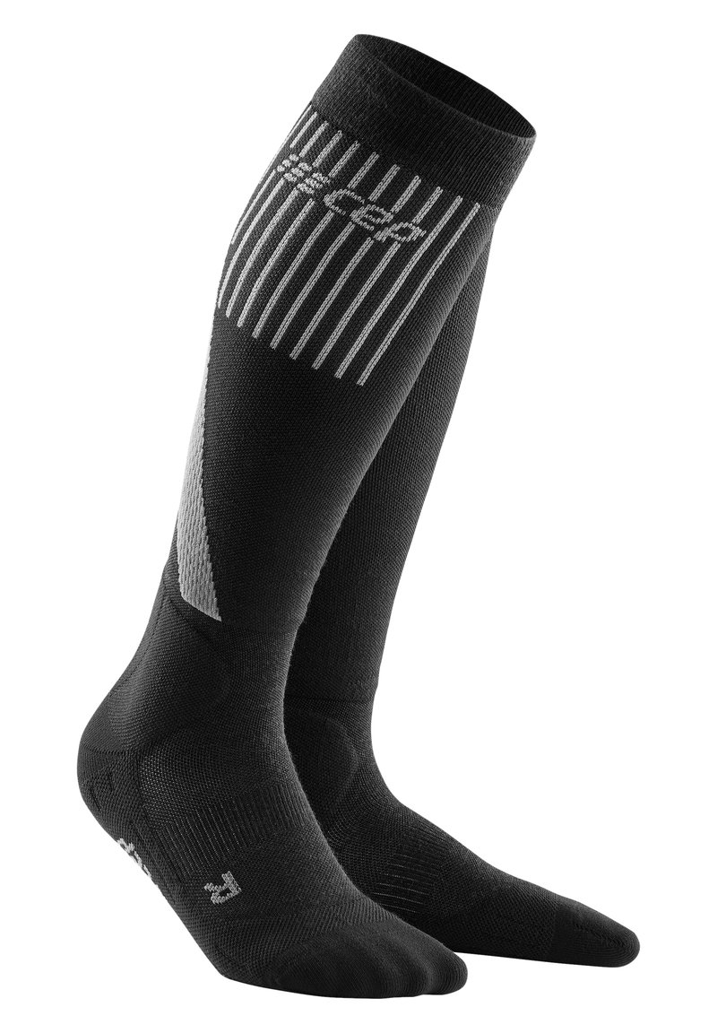 Zwart, knielange compressiekousen met een geribbeld patroon, voorzien van een reflecterend logo en diagonale paneelaccenten in grijs.