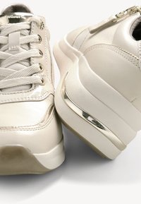 Beezid sneaksid, millel on sile nahk pealispind, tekstuuriga paelad, külgpakk ja metallhedelad kandadel. Omab pehmet talla.