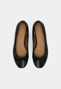 Čierne baletné baleríny s hladkým povrchom, zaoblenou špičkou a malým detailom v podobe mašle. Vnútro zdobí leopardí vzor na béžovom pozadí.