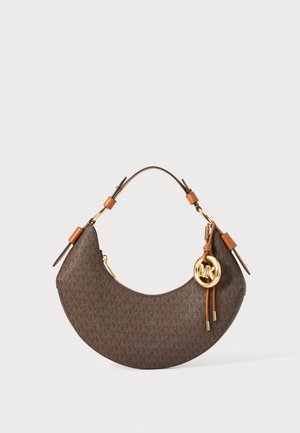 Borsa a mezzaluna marrone con tracolla in pelle color tan, hardware dorato e charm a forma di cerchio con logo MK che pende di lato.