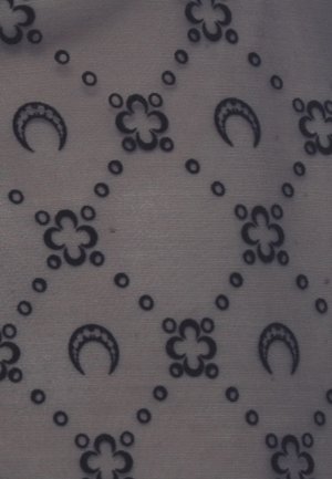 Motivo di forme a mezzaluna nere e fiori a quattro petali collegati da linee tratteggiate su uno sfondo di tessuto grigio texturizzato.