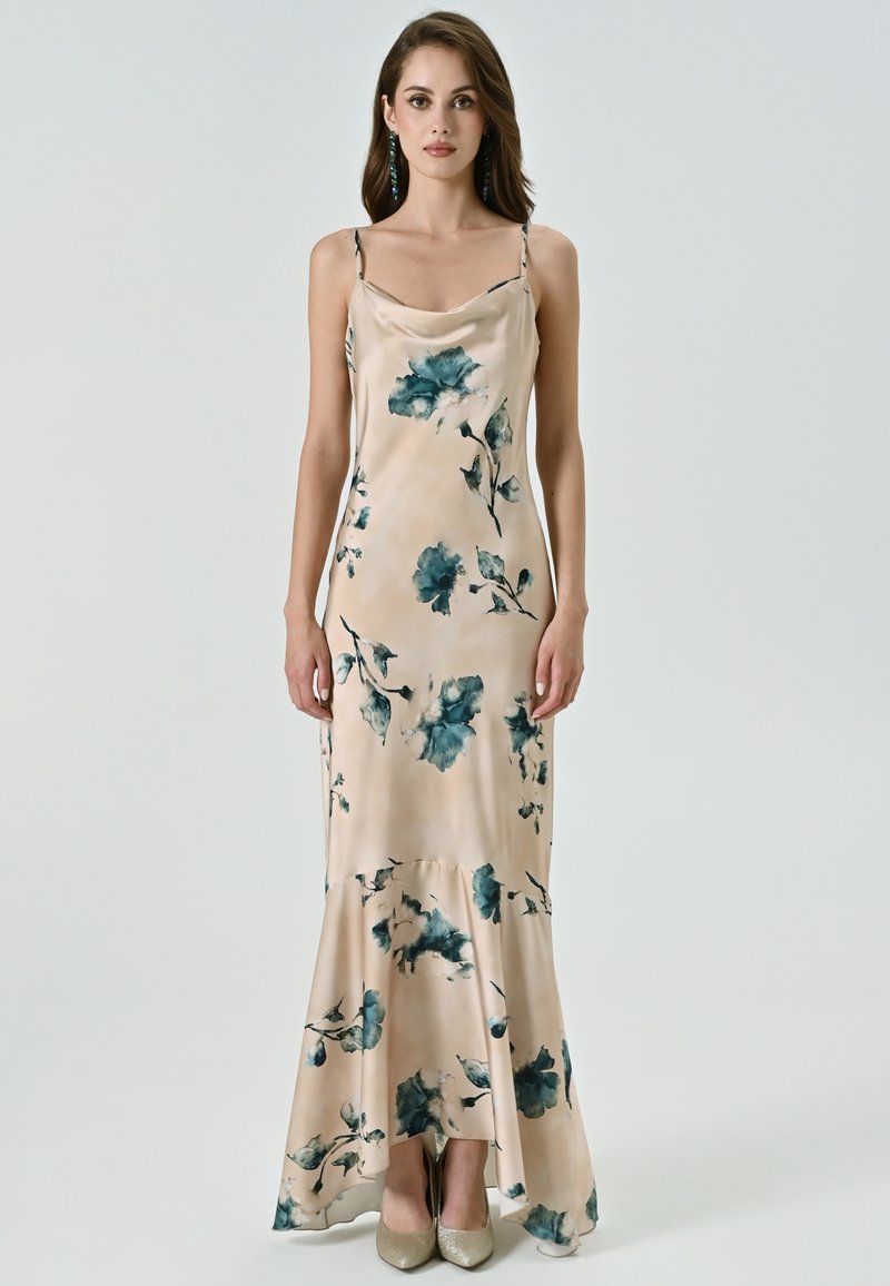 Robe maxi en satin rose pâle avec un motif floral turquoise foncé. Elle présente des bretelles spaghetti, un décolleté drapé et un ourlet évasé.