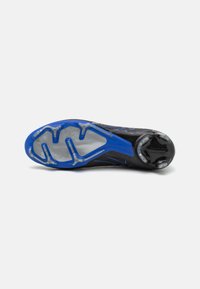 Black and blue cleat with translucent studs on the sole, designed for sports on grass or turf surfaces, shown from the bottom.