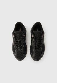 Černé sportovní boty s horní částí z síťoviny a syntetického materiálu, polstrovaným límcem a šněrováním s texturovanými prvky.