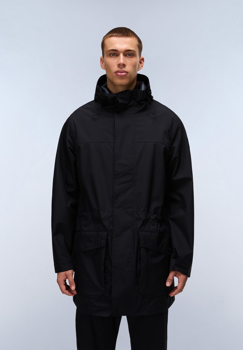 Svart vattentålig parka med hög krage, justerbar snodd och stora framfickor. Slät, matt yta och avslappnad passform.