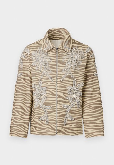Zebra-patterned jacket in beige and brown, featuring intricate floral beadwork, a zip front, and a structured collar. Soft texture.