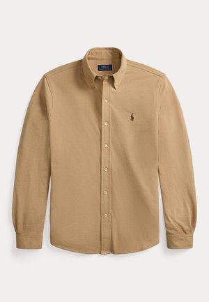 Beżowa koszula z długim rękawem zapinana na guziki, z kołnierzykiem na guziki i małym haftowanym logo na lewej piersi.