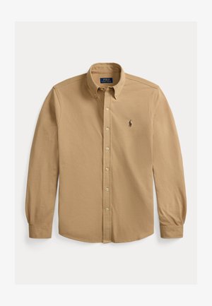 Beige langermet skjorte med knappelukking, knappet krage og liten brodert logo på venstre bryst.