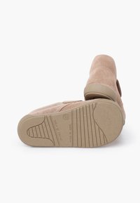 Children’s beige suede shoes with rubber soles, size 22, made in Spain, shown with one shoe lying on its side revealing the tread pattern.