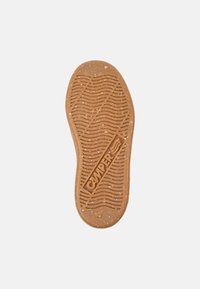 Semelle en caoutchouc couleur brun clair avec un motif de semelle ondulée. Logo "CAMPER" en relief, plus de petites speckles à travers le matériau.