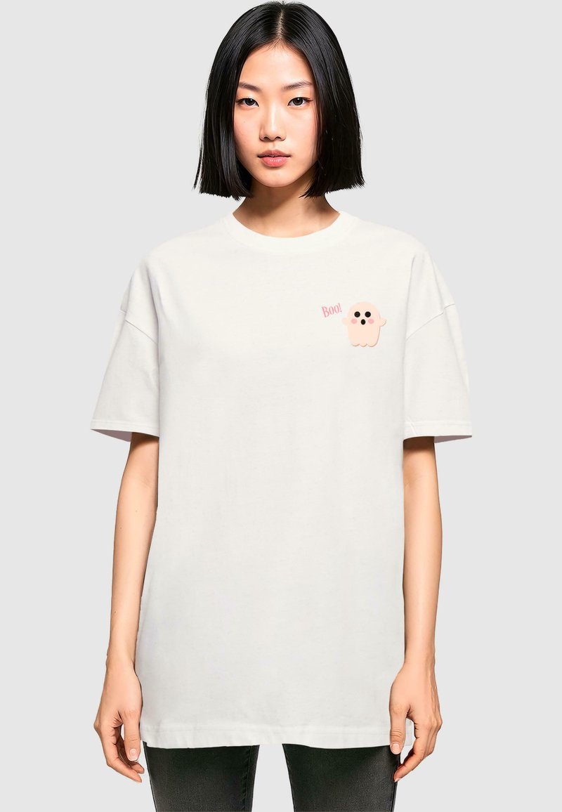 Witte oversized t-shirt gemaakt van katoen met korte mouwen. Bevat een roze spookgrafiek en de tekst "Boo!" in een speelse lettertype.