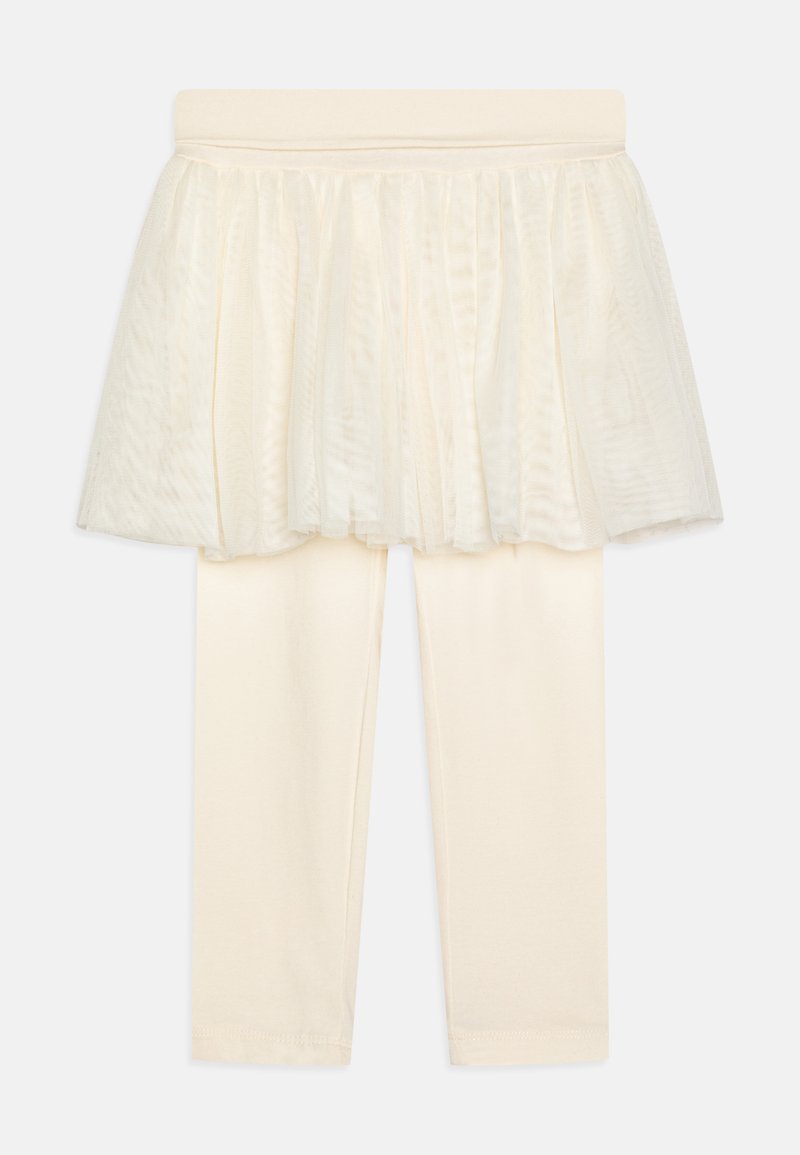 Leggings de couleur crème avec une jupe en tulle superposée, dotées d'une taille douce et d'une texture lisse. L'ensemble est simple et élégant.
