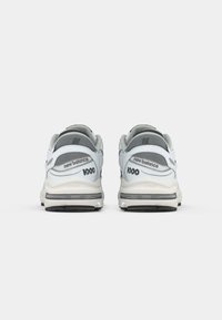 Grå og hvide New Balance sneakers med polstret overdel, mesh-detaljer, støttende hæl og sort gummisål med "1000" detalje.