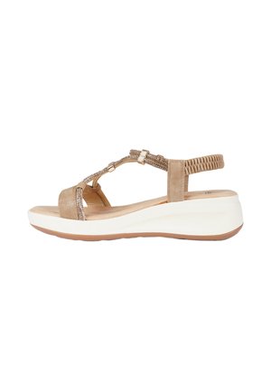 Sandalo da donna marrone chiaro con suola bianca imbottita, cinturino posteriore elastico intrecciato e cinturini decorativi con perline sul collo del piede.