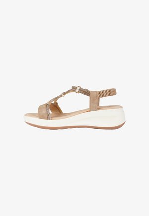 Sandalo da donna marrone chiaro con suola bianca imbottita, cinturino posteriore elastico intrecciato e cinturini decorativi con perline sul collo del piede.