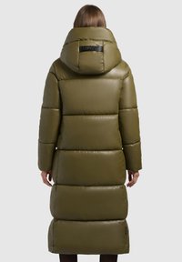 Lang, olijfgroene pufferjas met een grote capuchon, gequilt panelen en een logo detail op de achterkant. Glad, glanzend textuur.