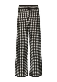 Zwart-wit geblokte wijde broek van een gestructureerde stof met een elastische tailleband met zwarte strepen. Klassiek patroon en losse pasvorm.
