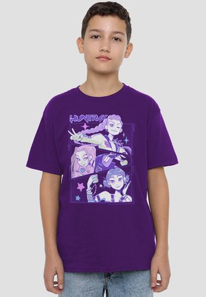 Lila Baumwoll-T-Shirt mit einem grafischen Design, das drei Comicfiguren zeigt, umrandet von Hellblau, vor einem sternenübersäten Hintergrund.